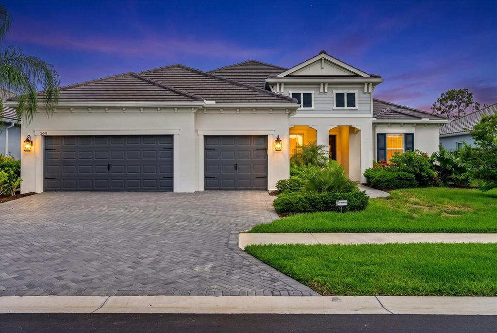 A two-story house with a two-car garage, paved driveway, and a landscaped front yard — 2641 BUTTERFLY JASMINE TRAIL, SARASOTA, FL
