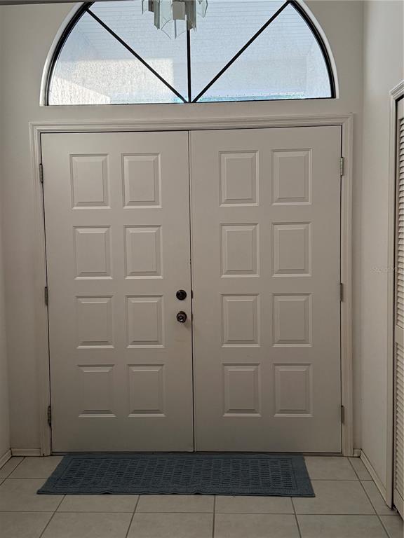 A white double front door with a large arched transom window above a tiled floor — 4675 32ND COURT E, BRADENTON, FL