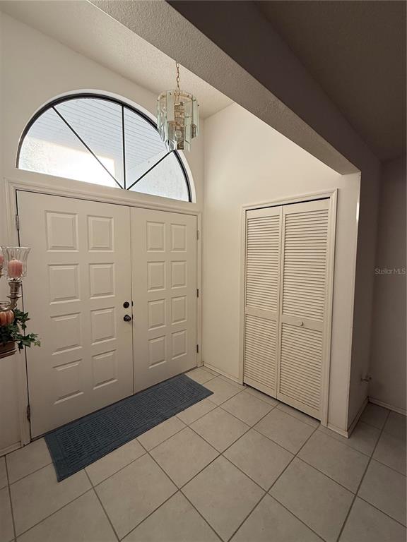 An entryway features white double doors, a louvered closet, and a tiled floor — 4675 32ND COURT E, BRADENTON, FL