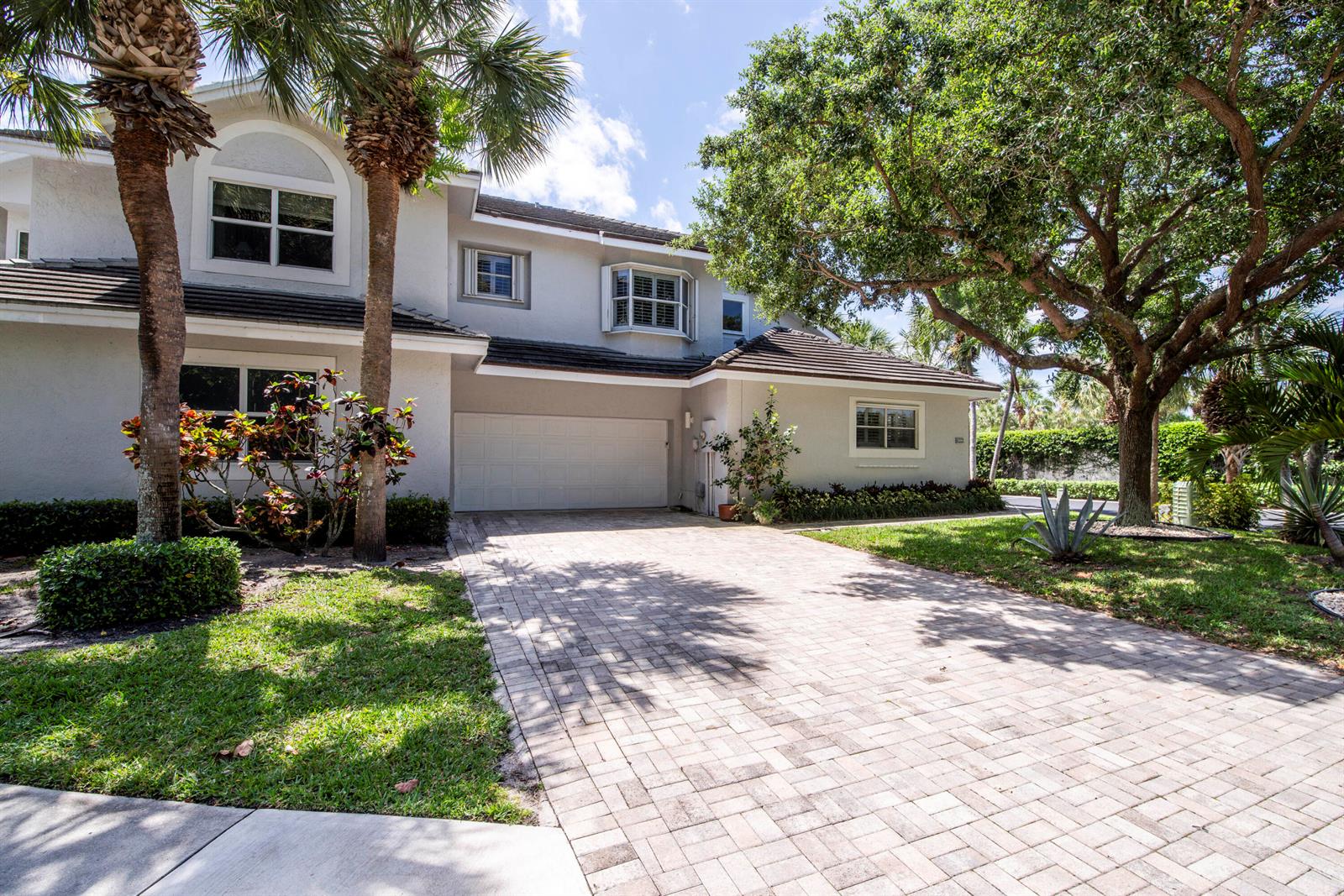 A two-story house with a paved driveway, a two-car garage, and mature landscaping — 3004 Mainsail Circle, Jupiter FL 33477, JUPITER, FL