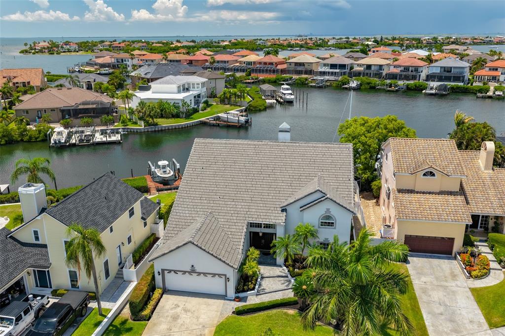 An aerial view shows a waterfront house with a gray roof and a two-car garage — 929 SYMPHONY ISLES BOULEVARD, APOLLO BEACH, FL