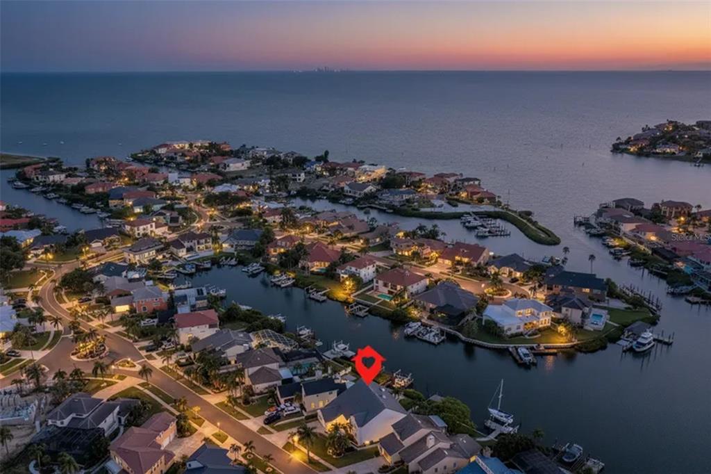 An aerial view shows a waterfront house with a red marker in a coastal neighborhood — 929 SYMPHONY ISLES BOULEVARD, APOLLO BEACH, FL