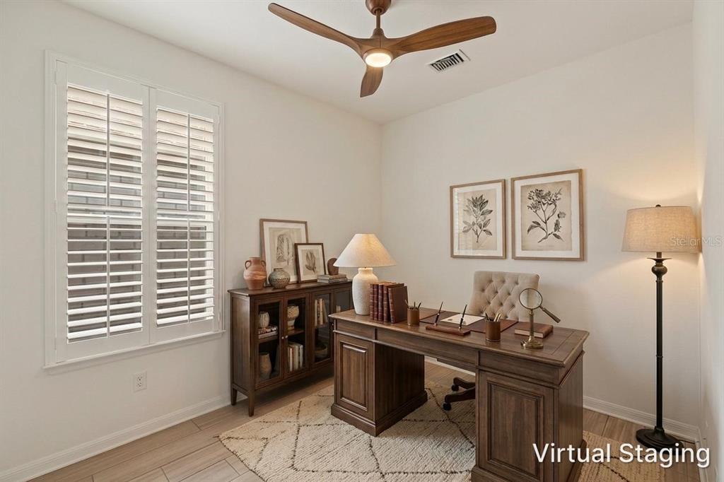 A home office features a wooden desk, a cabinet, a ceiling fan, and virtual staging — 19689 FORT KING RUN, BROOKSVILLE, FL