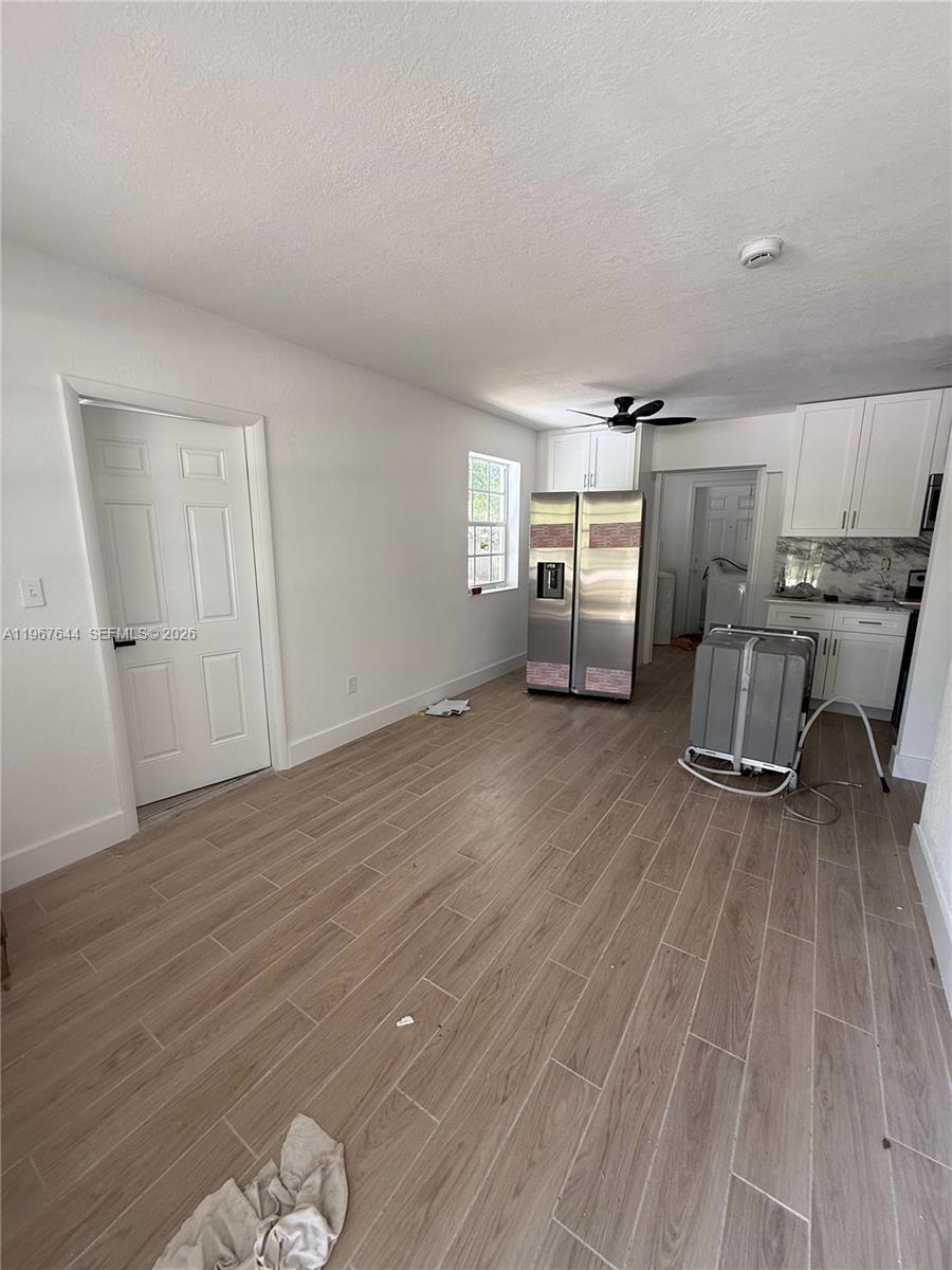 A kitchen with white cabinets, stainless steel appliances, and light wood-look tile flooring — 5264 NE 15th Ave, Pompano Beach FL 33064, POMPANO BEACH, FL