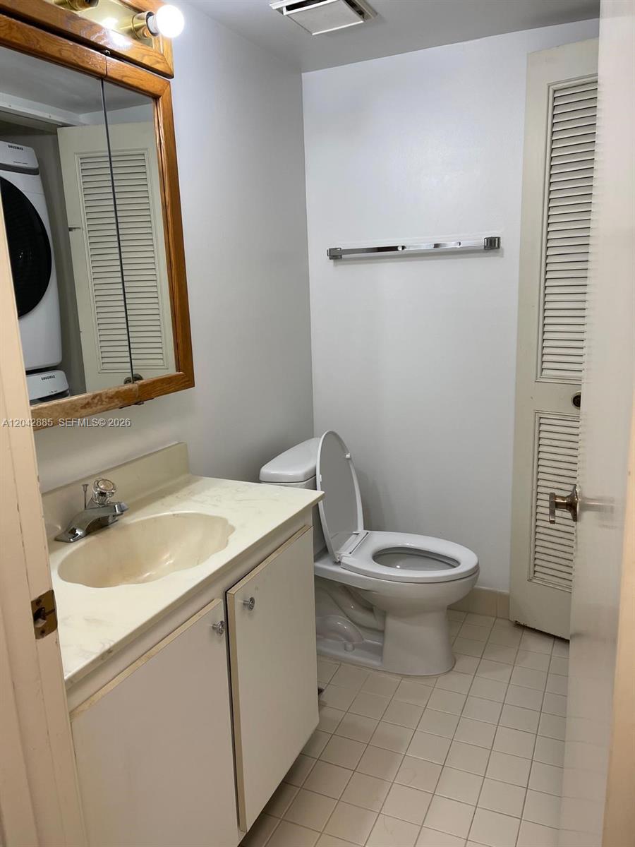A bathroom features a vanity with a sink, a toilet, and a laundry closet — 20840 San Simeon Way # 308, Miami FL 33179, MIAMI, FL