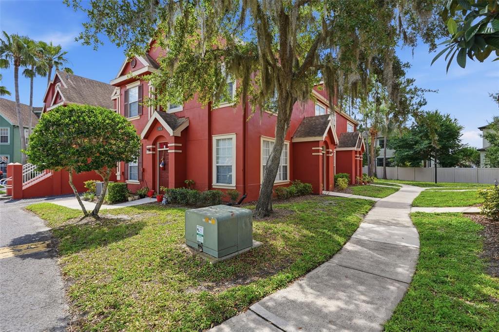 A red two-story townhouse with a sidewalk and a green utility box in the yard — 10436 WHITE LAKE COURT UNIT 10436, TAMPA, FL
