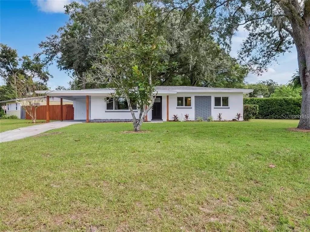 A single-story white house with a carport and a large front lawn under trees — 3101 OXFORD STREET, ORLANDO, FL