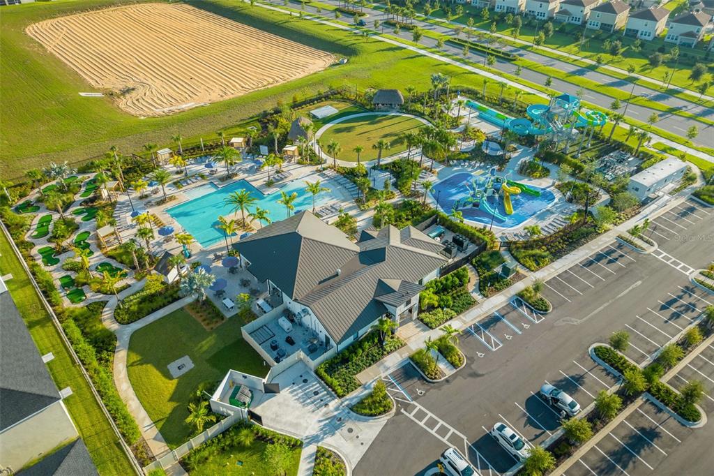 An aerial view of a community clubhouse featuring a swimming pool, water slides, and mini-golf — 740 DROP SHOT DRIVE, DAVENPORT, FL