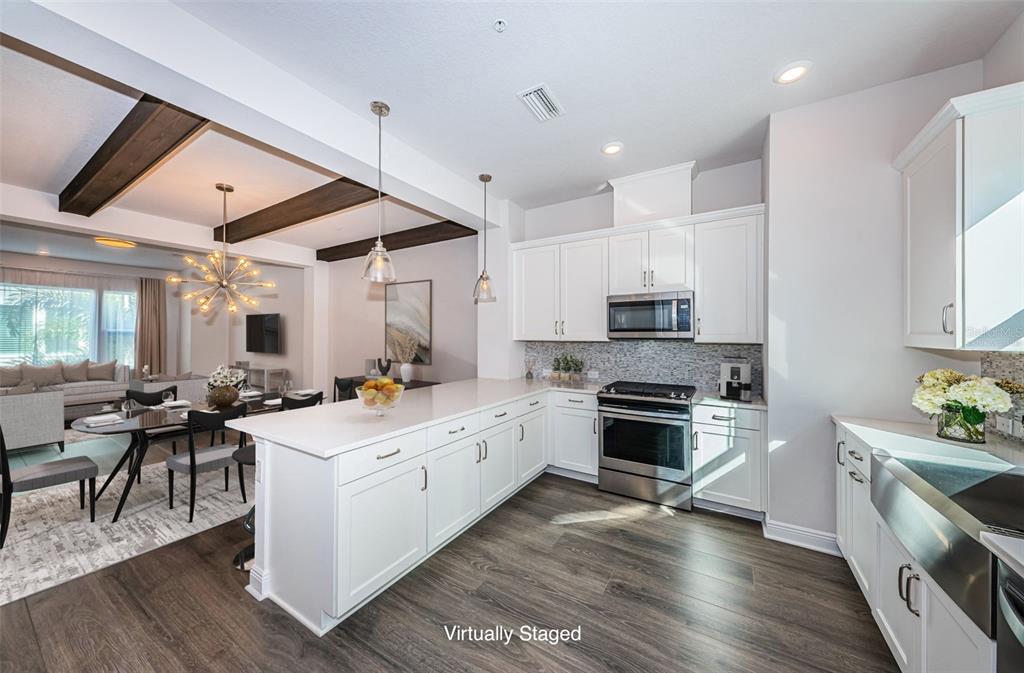 A modern kitchen with white cabinets, stainless steel appliances, and a large island — 815 BURLINGTON AVENUE N, ST PETERSBURG, FL