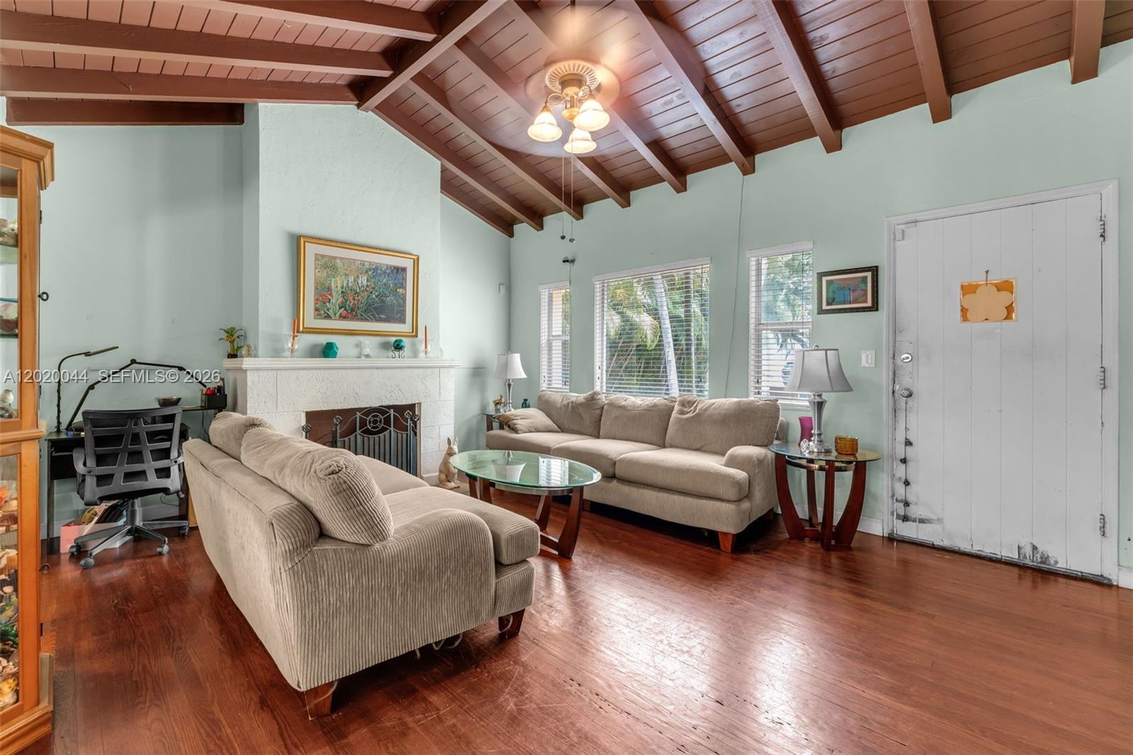 A living room features a vaulted wood-beam ceiling, a fireplace, and hardwood flooring — 28 NE 48th St, Miami FL 33137, MIAMI, FL