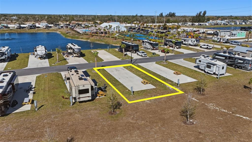 An aerial view shows a vacant concrete RV pad highlighted in yellow at a campground — 232 RIVERCLUB COURT, PUNTA GORDA, FL