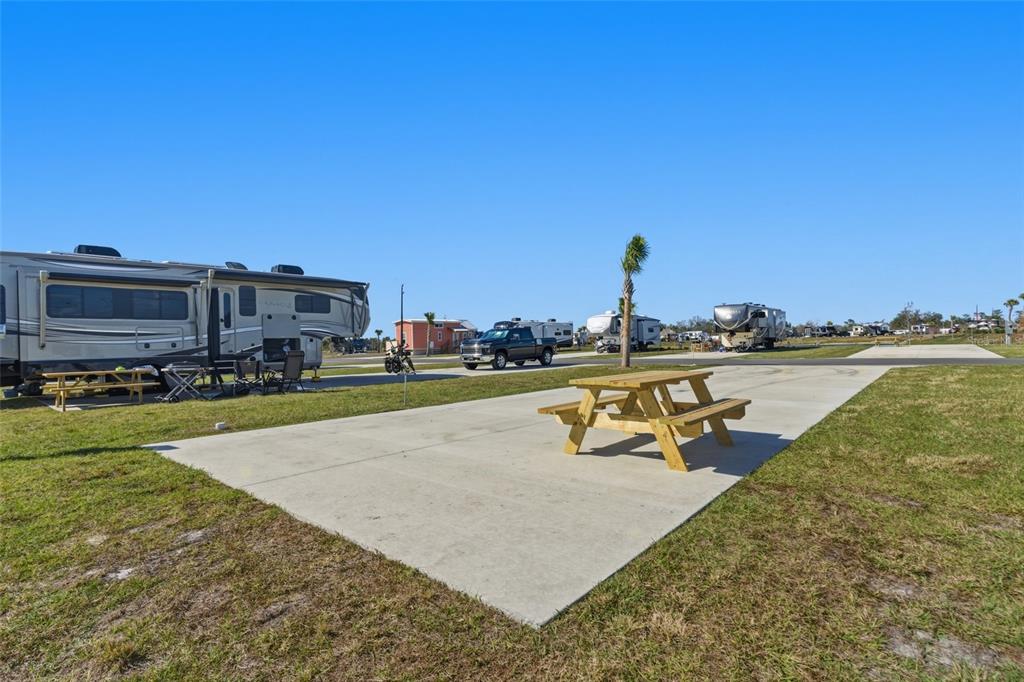 A concrete pad with a wooden picnic table sits in an outdoor RV park — 232 RIVERCLUB COURT, PUNTA GORDA, FL