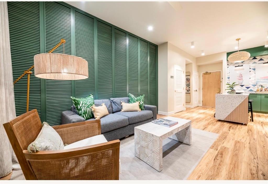 A living room features a green louvered accent wall, a grey sofa, and a wood chair — 3151 SUNSET WALK DRIVE UNIT 402, KISSIMMEE, FL