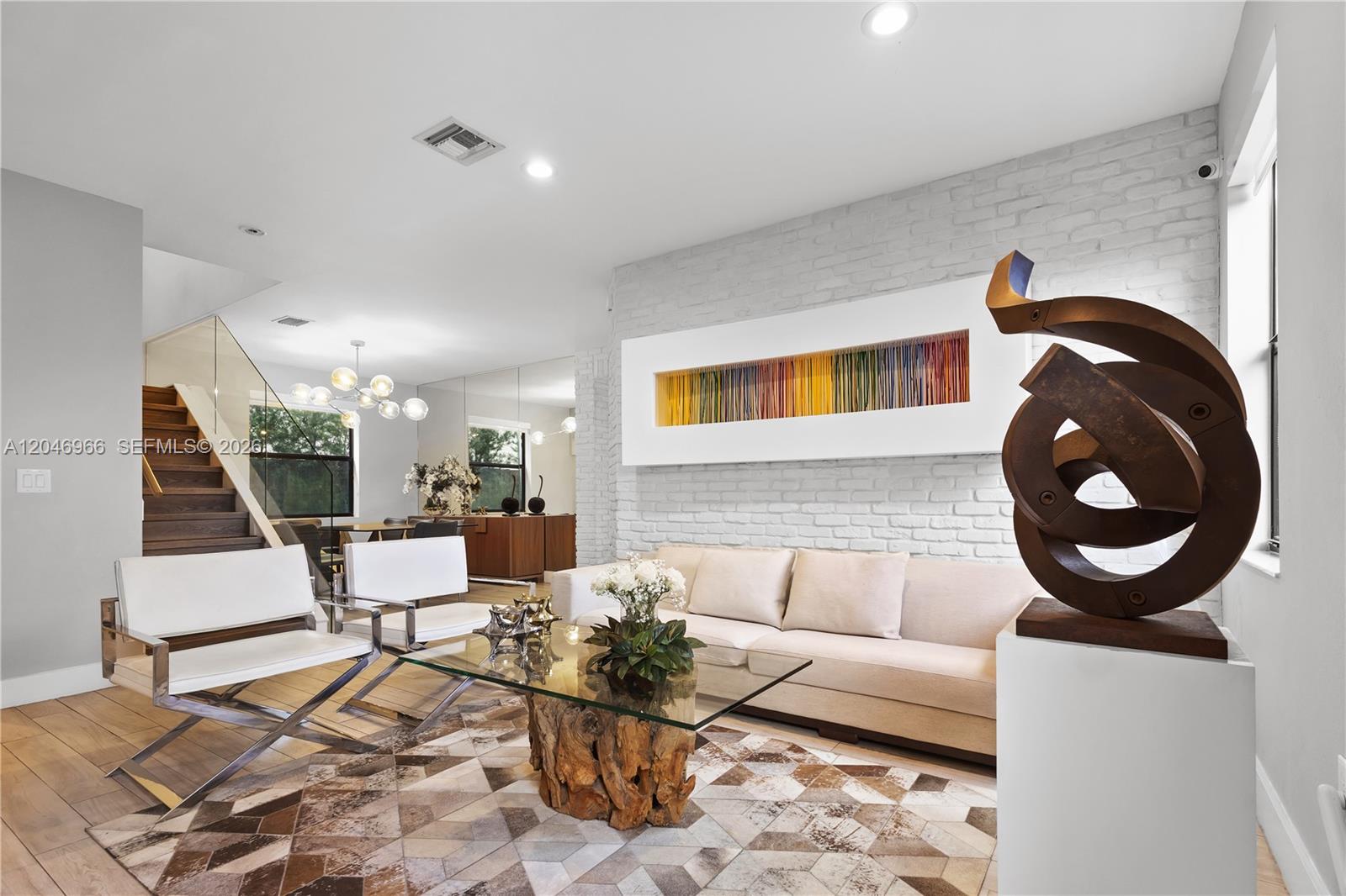 A living room features a white brick wall, a modern sculpture, and a glass coffee table — 8774 NW 103rd Ave, Doral FL 33178, DORAL, FL