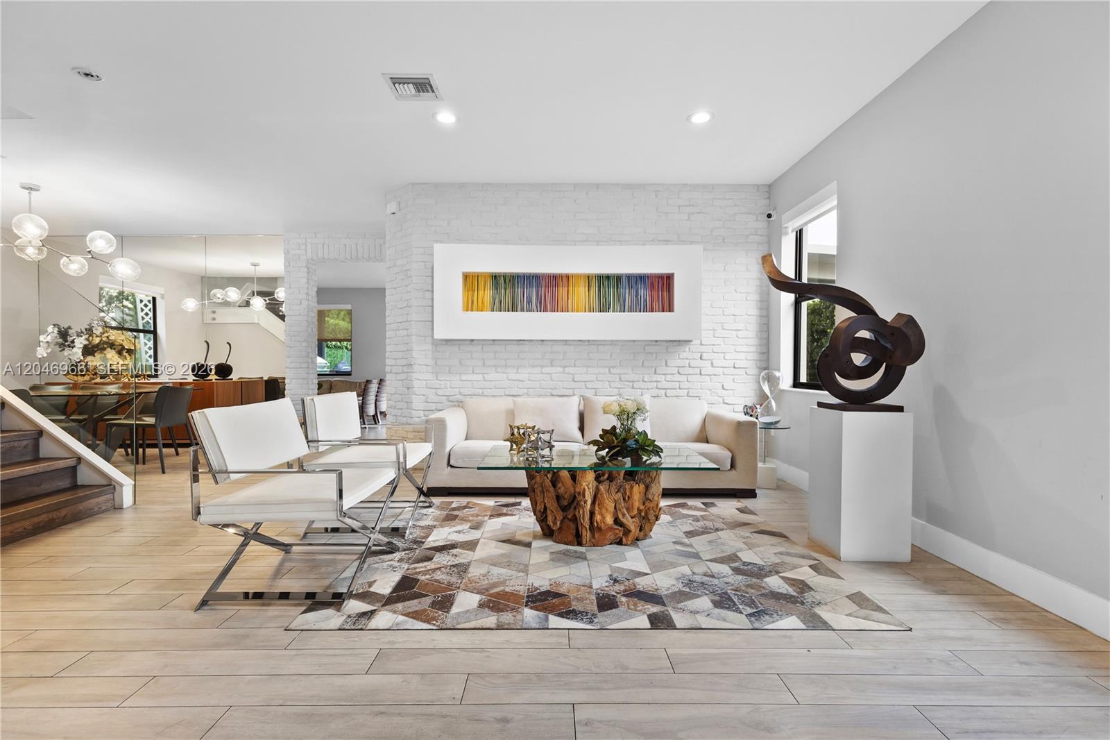A modern living room features a white brick wall, geometric rug, and wood-base coffee table — 8774 NW 103rd Ave, Doral FL 33178, DORAL, FL