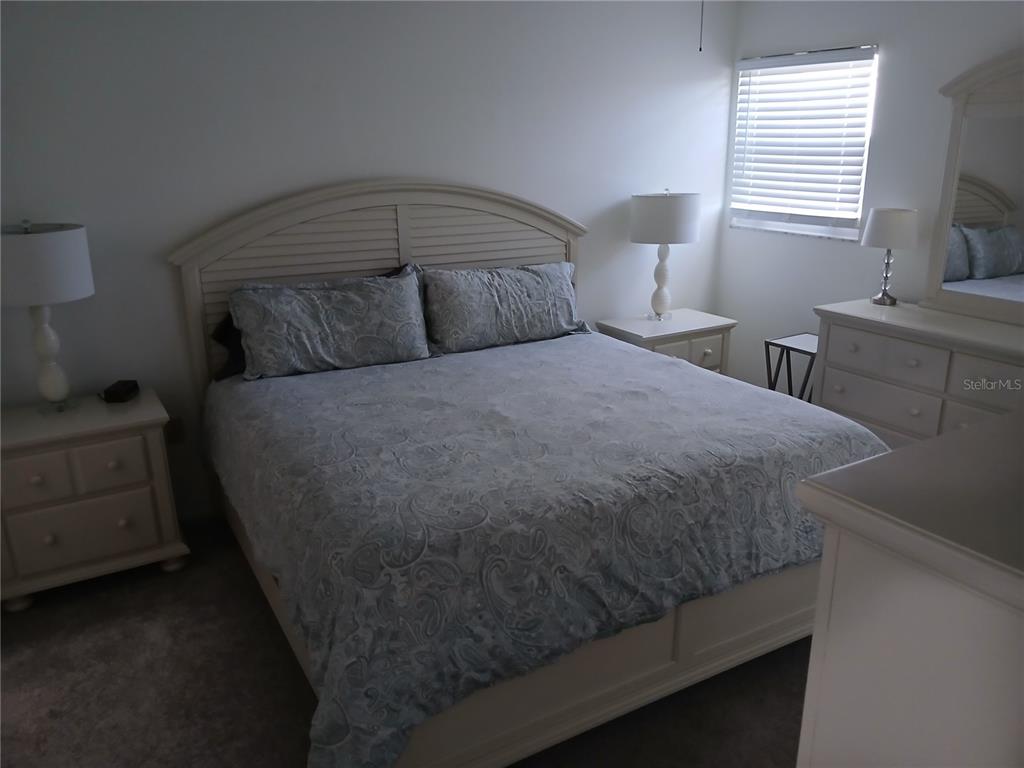 A bedroom features a light-colored bed frame, matching nightstands, a dresser, and a window — 913 WATERSIDE LANE UNIT 913, BRADENTON, FL