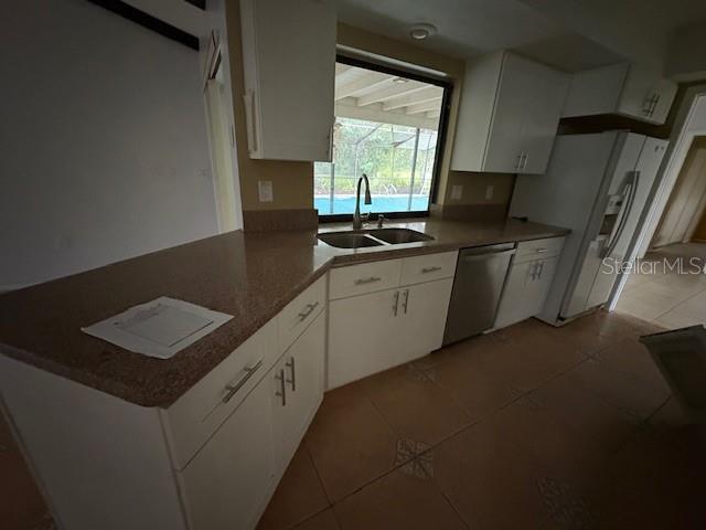 A kitchen features white cabinets, granite countertops, a stainless steel dishwasher, and a window view — 4051 BENT TREE BOULEVARD, SARASOTA, FL