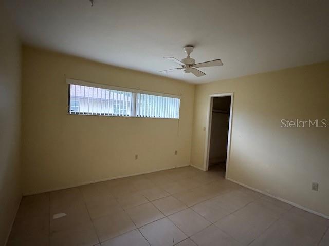 An empty bedroom features light-colored walls, tile flooring, a ceiling fan, and a window — 4051 BENT TREE BOULEVARD, SARASOTA, FL