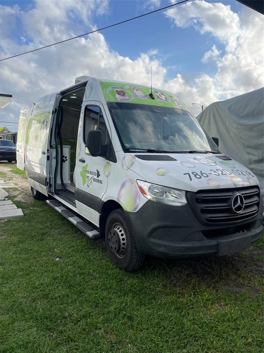 A white Mercedes-Benz Sprinter van used for mobile pet grooming is parked on grass — 11700 SW Bird Road, Unincorporated Dade County FL 33175, UNINCORPORATED DADE COUNTY, FL