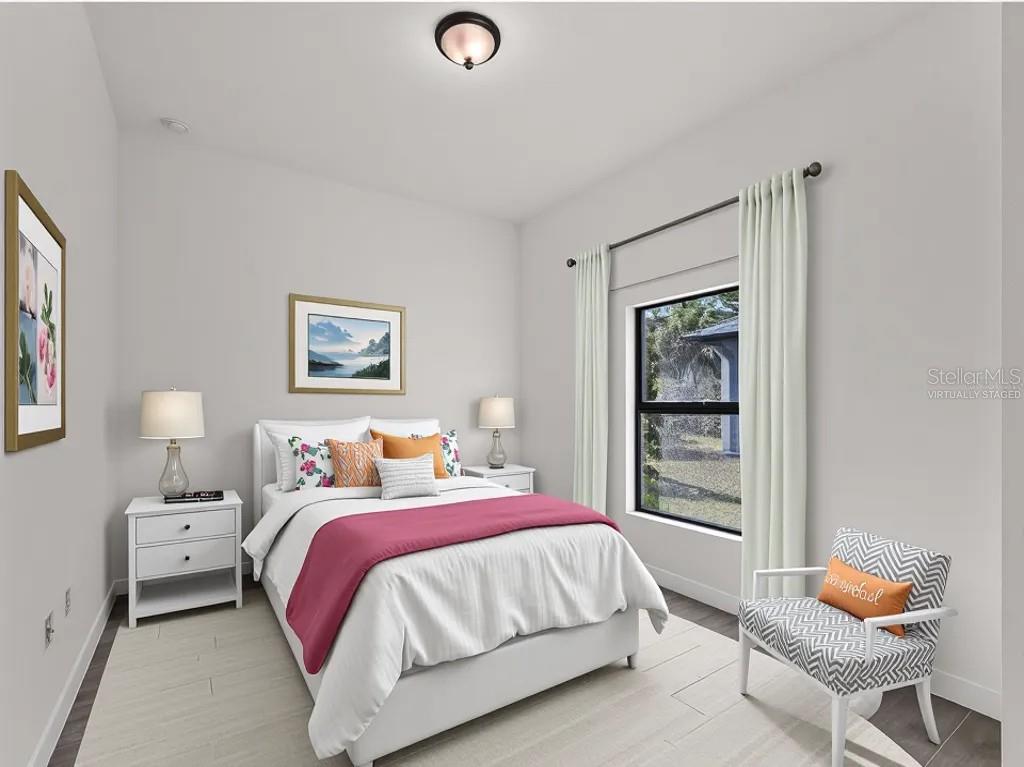 This virtually staged bedroom features a bed, two nightstands, a chair, and a window — 3085 STOCKTON AVENUE, NORTH PORT, FL