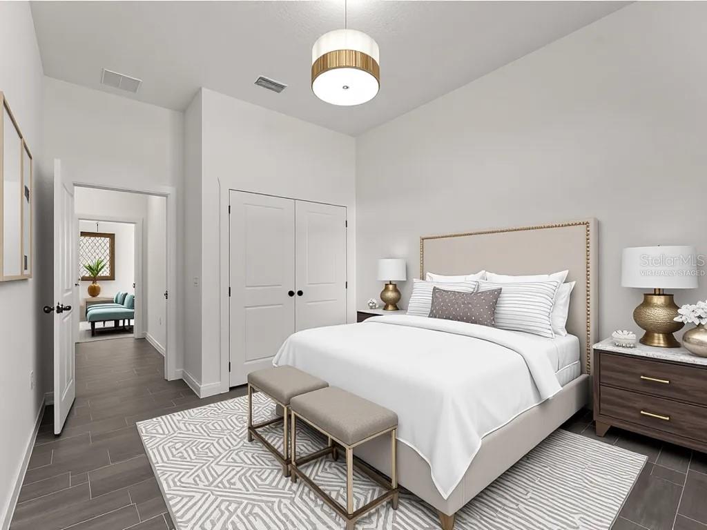 A bedroom with a bed, two benches, a closet, and a view into another room — 3085 STOCKTON AVENUE, NORTH PORT, FL