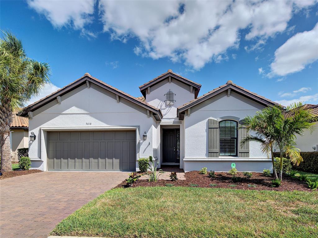 A single-story house features a two-car garage, a front entrance, and a landscaped yard — 5616 SCARLOTTI STREET, NOKOMIS, FL
