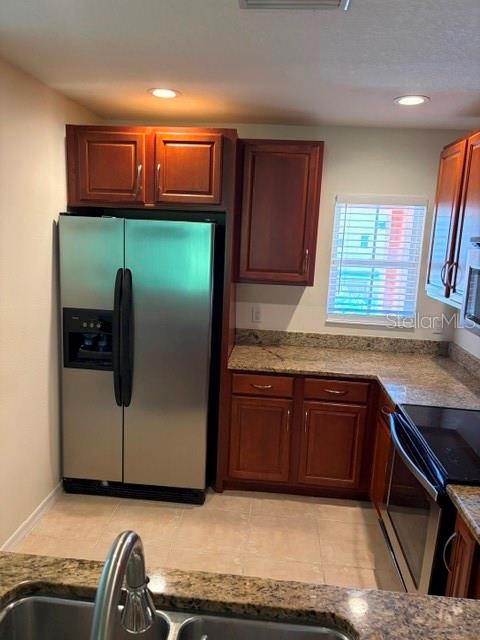 A kitchen features stainless steel appliances, wood cabinets, and granite countertops — 8858 WHITE SAGE LOOP, LAKEWOOD RANCH, FL