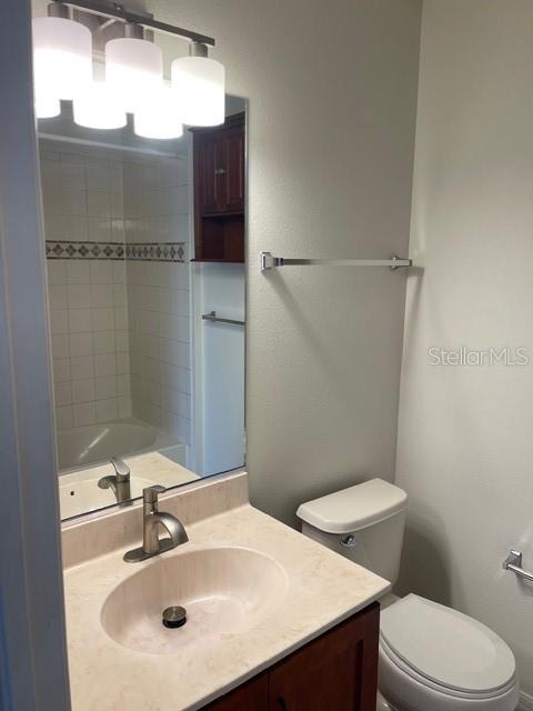 A bathroom features a vanity with a sink, a mirror, a toilet, and a shower — 8858 WHITE SAGE LOOP, LAKEWOOD RANCH, FL