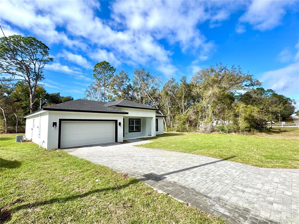 A white single-story house with a two-car garage and a paved driveway — 9082 N CORTLANDT DRIVE, CITRUS SPRINGS, FL