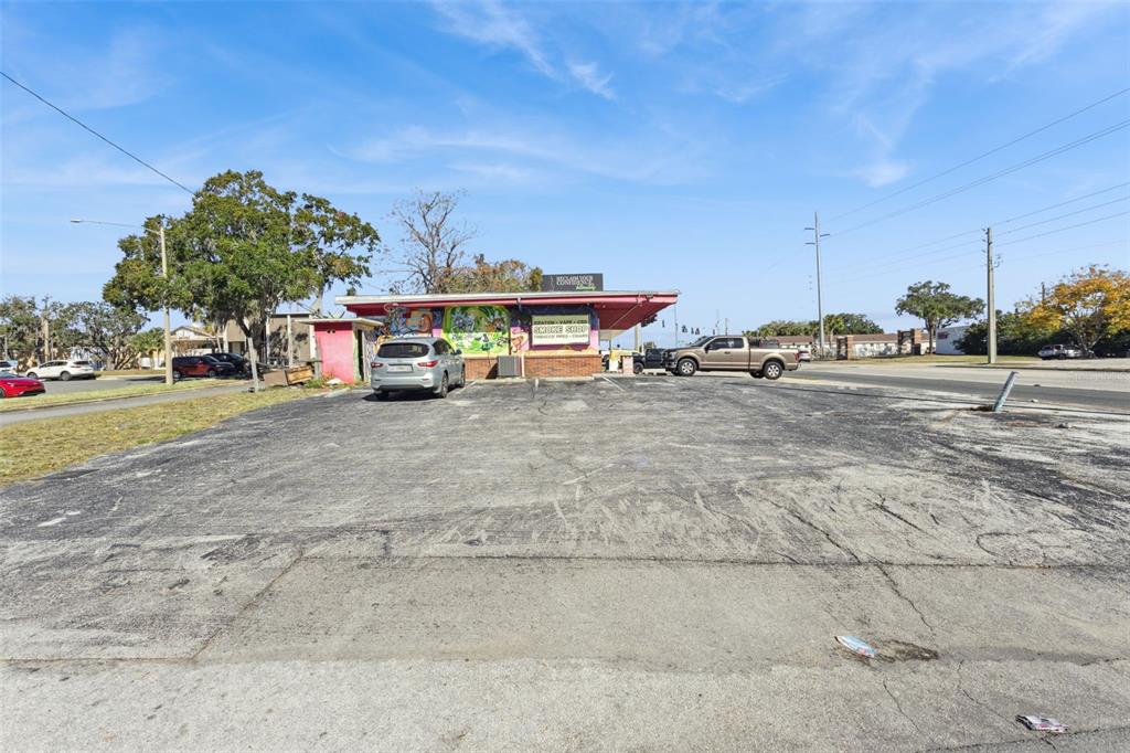 A small commercial building with a parking lot under a clear blue sky — 107 S 14TH STREET, LEESBURG, FL