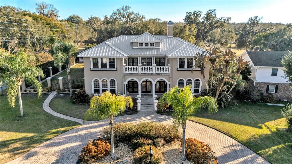 An aerial view of a two-story house with a metal roof and a circular driveway — 1665 BLUE HERON LANE, LAKELAND, FL