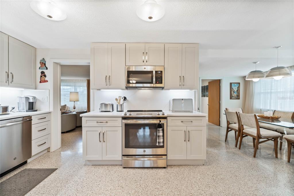 A kitchen with light-colored cabinets, stainless steel appliances, and speckled flooring — 809 E 15TH AVENUE, NEW SMYRNA BEACH, FL