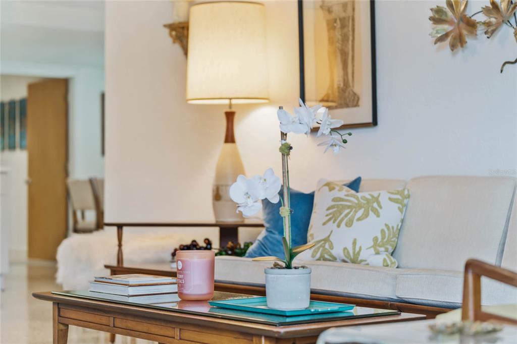 A living room features a mid-century modern lamp, a sofa with decorative pillows, and plants — 809 E 15TH AVENUE, NEW SMYRNA BEACH, FL