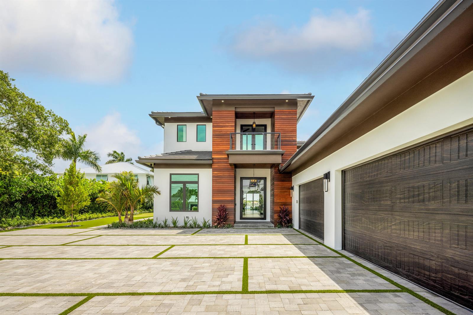 A modern two-story house with a wood-paneled facade, balcony, and a large paver driveway — 1708 N Lakeside Drive, FL 33460, FL