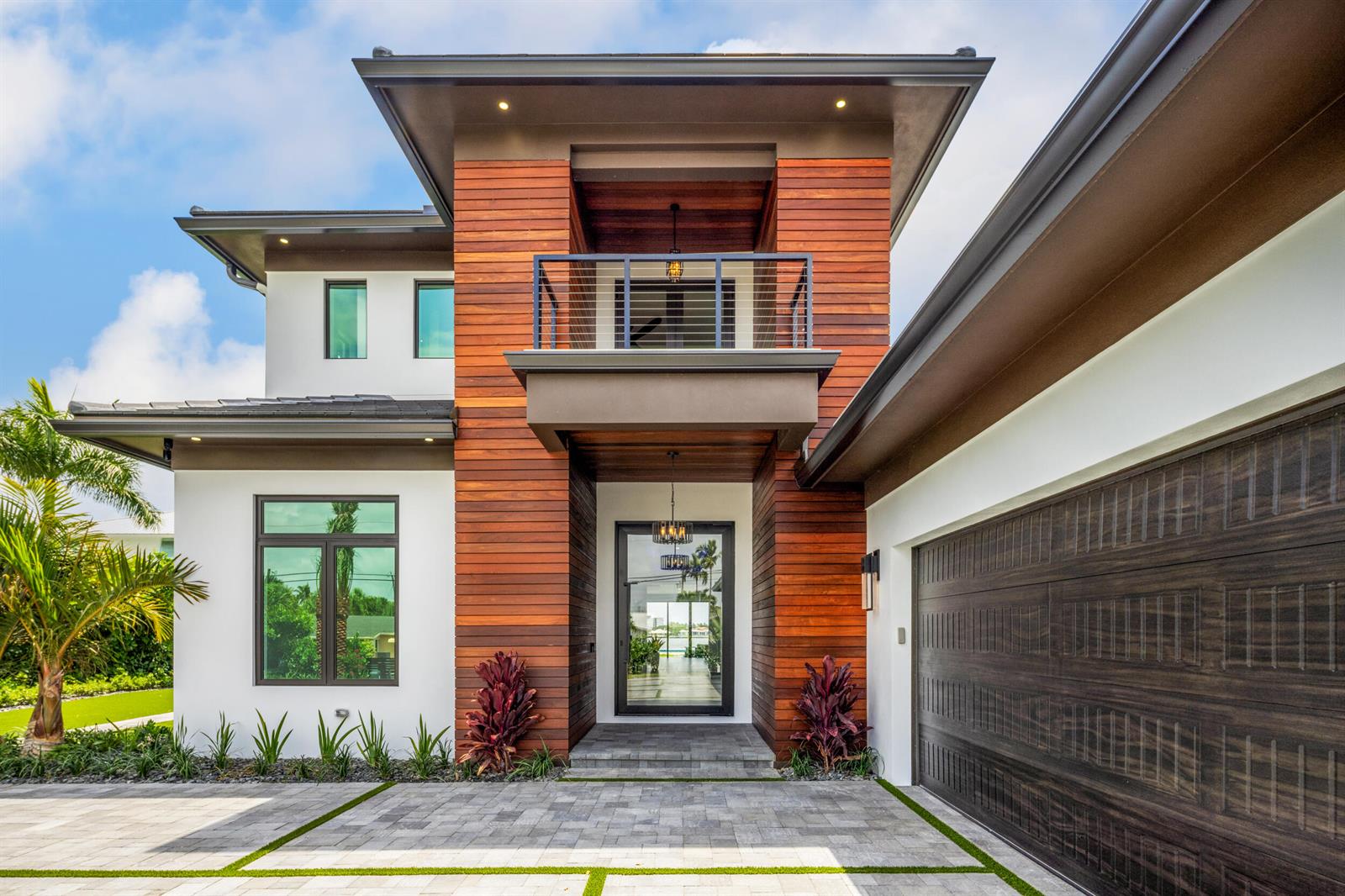 The exterior of a modern two-story house features white walls, wood siding, and a garage — 1708 N Lakeside Drive, FL 33460, FL