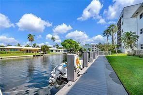 A boat is docked along a wooden pier next to a canal and apartment building — 1461 S Ocean Boulevard # 328, Pompano Beach FL 33062, POMPANO BEACH, FL