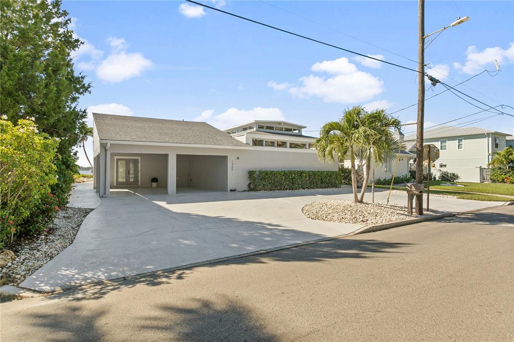 A single-story house with a two-car carport and a concrete driveway under a blue sky — 1905 4TH STREET W, PALMETTO, FL