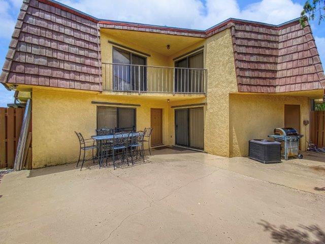 A two-story yellow house with a balcony, a patio dining set, and a charcoal grill — 62 Springdale Circle, Palm Springs FL 33461, PALM SPRINGS, FL