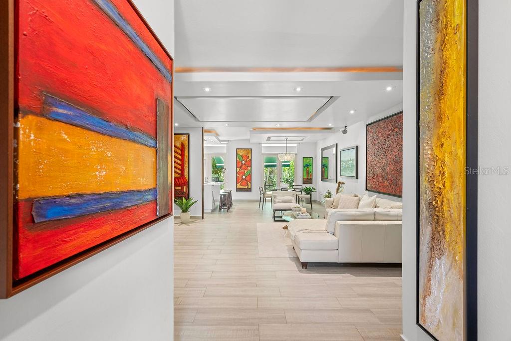 A bright, open-concept living area features light tile flooring, modern recessed lighting, and colorful artwork — 693 PR UNIT 511, VEGA ALTA, PR