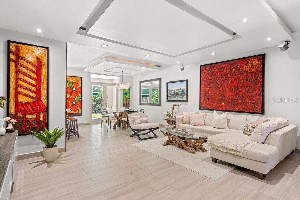 A living room features a white sectional sofa, a driftwood coffee table, and vibrant abstract art — 693 PR UNIT 511, VEGA ALTA, PR