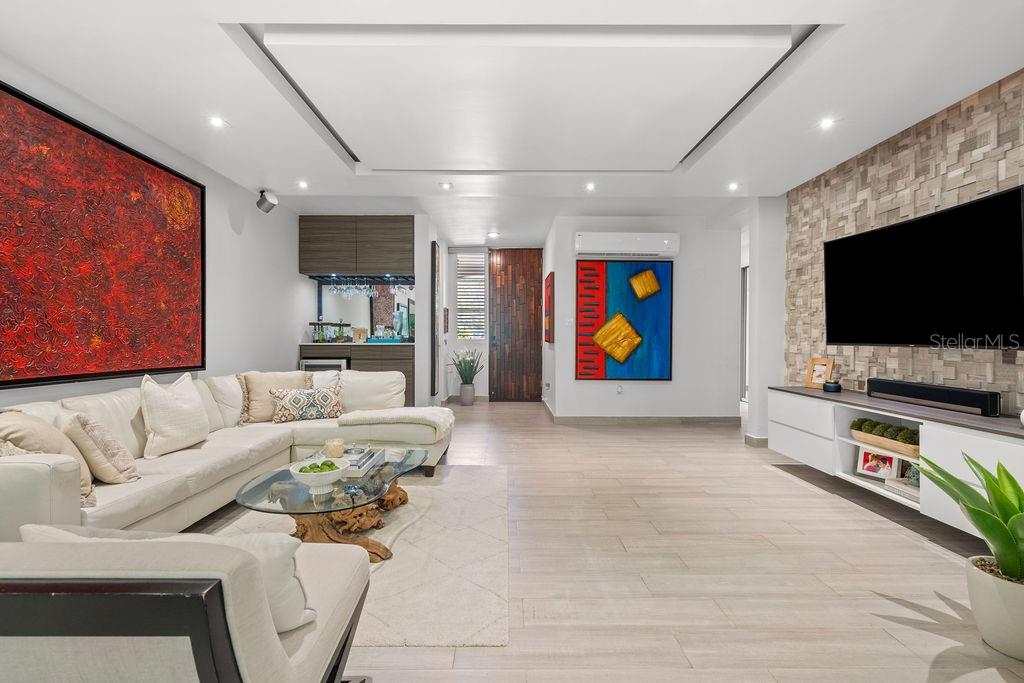 A modern living room features a white sectional sofa, a stone accent wall, and artwork — 693 PR UNIT 511, VEGA ALTA, PR