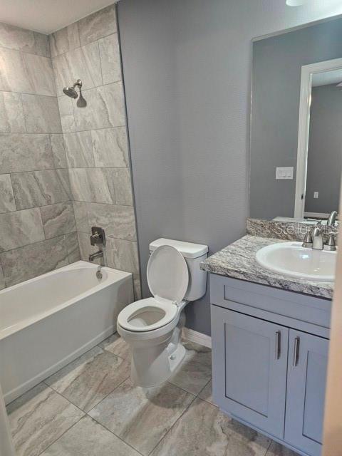 A bathroom features a tiled shower-tub combo, a toilet, and a vanity with a sink — 650 NW 5TH STREET, OCALA, FL