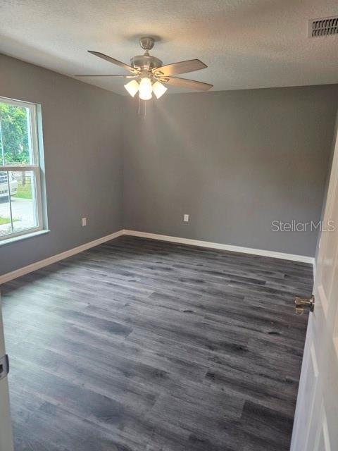 An empty bedroom features gray walls, wood-look flooring, and a ceiling fan — 650 NW 5TH STREET, OCALA, FL