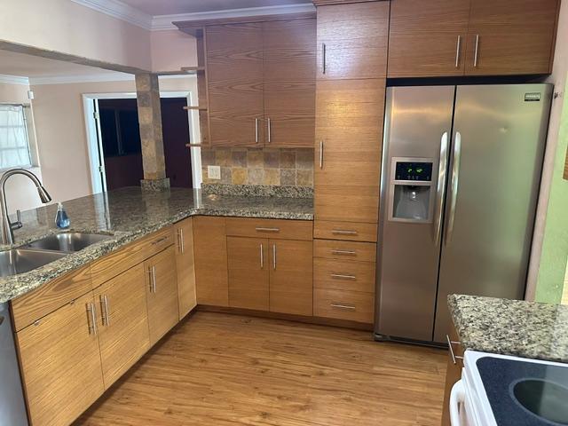 A kitchen features wood-grain cabinets, granite countertops, stainless steel appliances, and a double sink — 732 SE 11th Avenue, Deerfield Beach FL 33441, DEERFIELD BEACH, FL