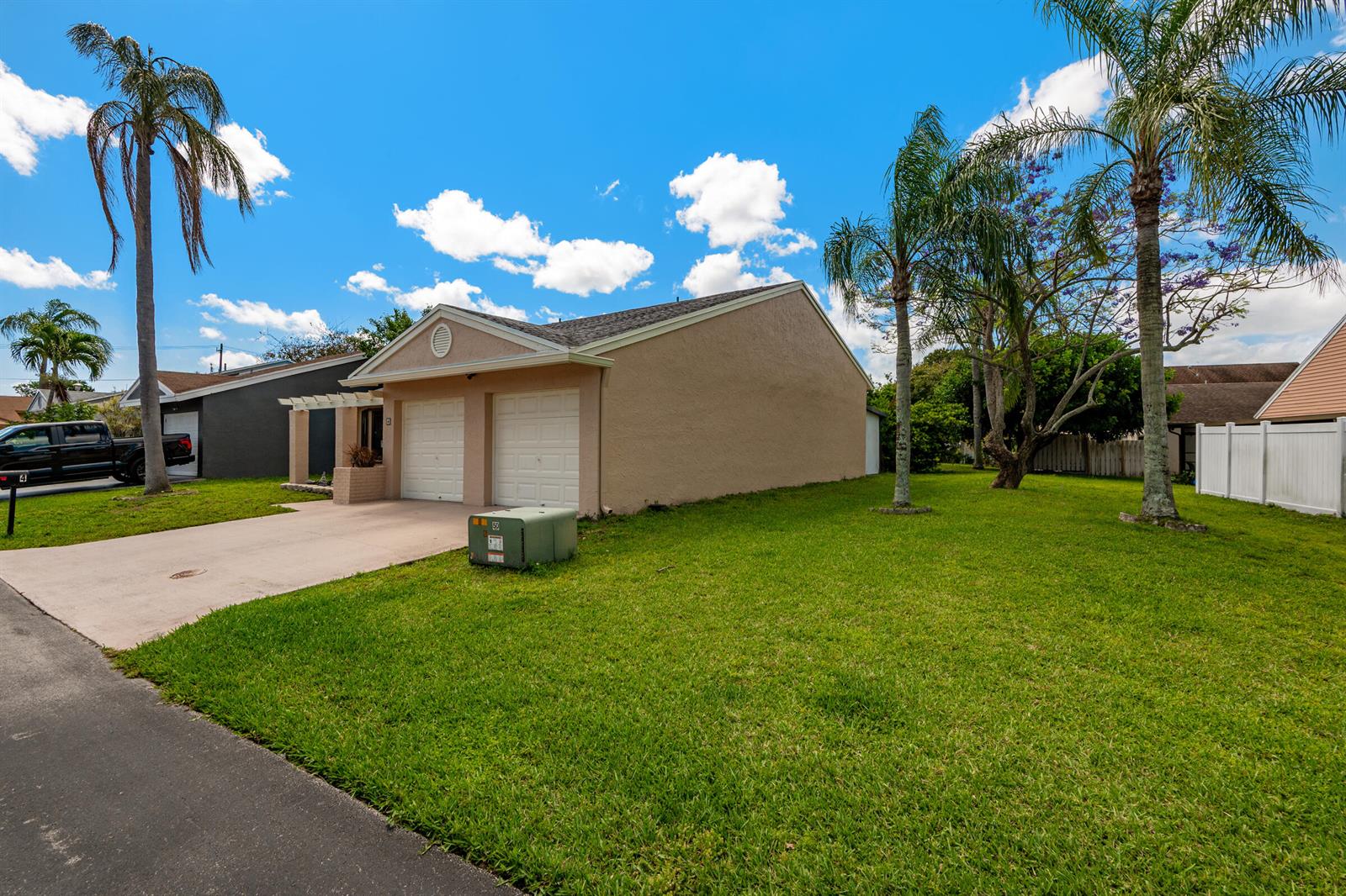 A tan, single-story house with a two-car garage and a large, grassy side yard — 4 Verwood Way, Boynton Beach FL 33426, BOYNTON BEACH, FL