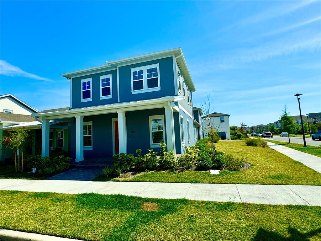 A two-story blue house with a front porch and a sidewalk in a suburban neighborhood — 9726 NERUDA STREET, ORLANDO, FL