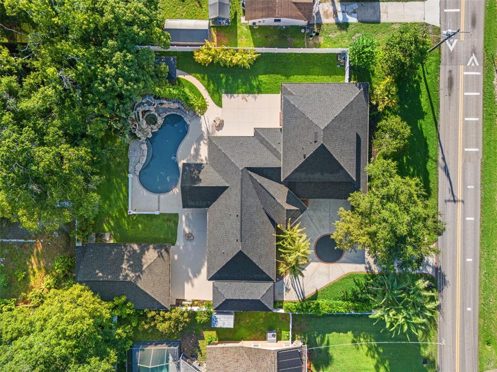 An aerial view shows a house with a dark roof, a pool, and a circular driveway — 2521 LAKE ELLEN DRIVE, TAMPA, FL