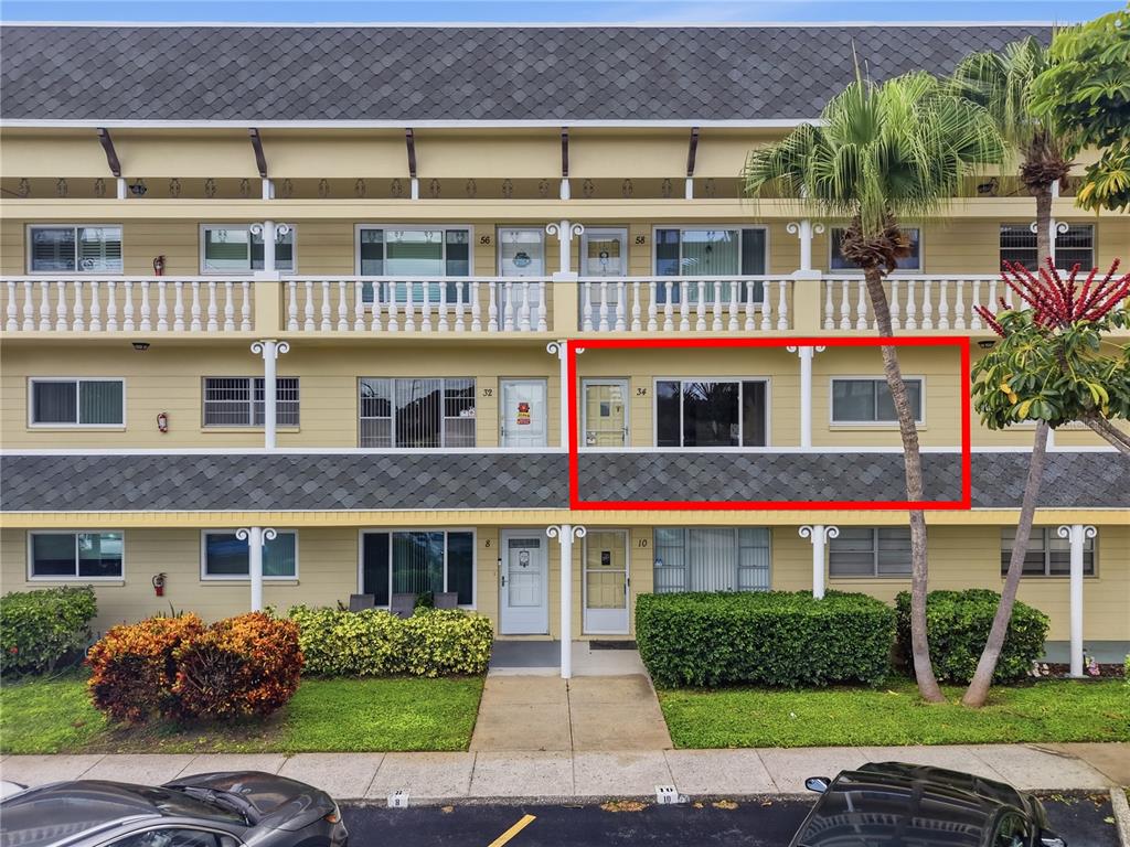 A three-story apartment building exterior features a red-outlined unit on the second floor — 2458 FLORENTINE WAY UNIT 34, CLEARWATER, FL