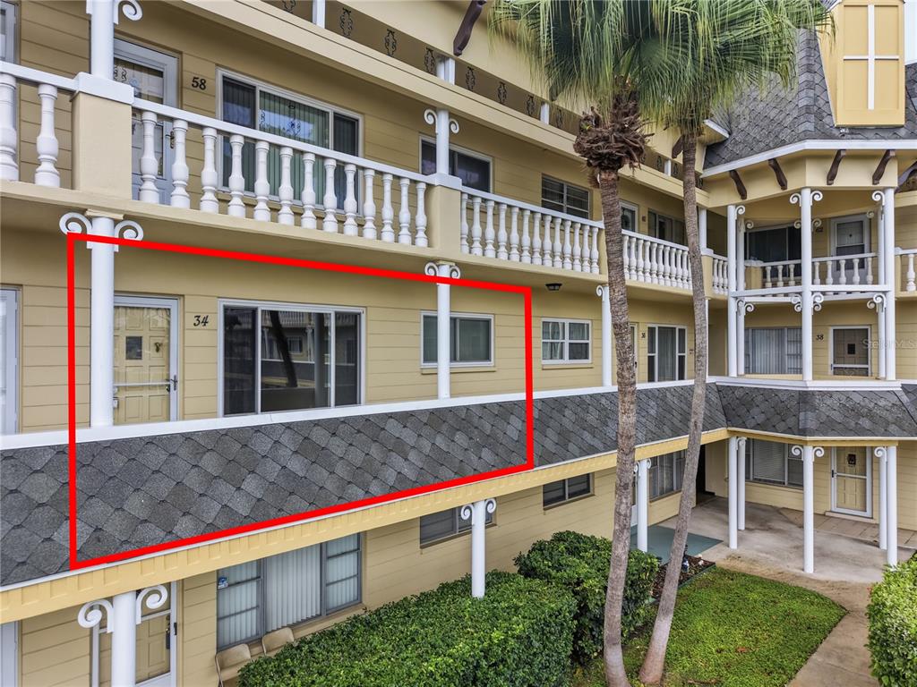 An exterior view of a multi-story apartment building featuring a balcony with unit number 34 — 2458 FLORENTINE WAY UNIT 34, CLEARWATER, FL