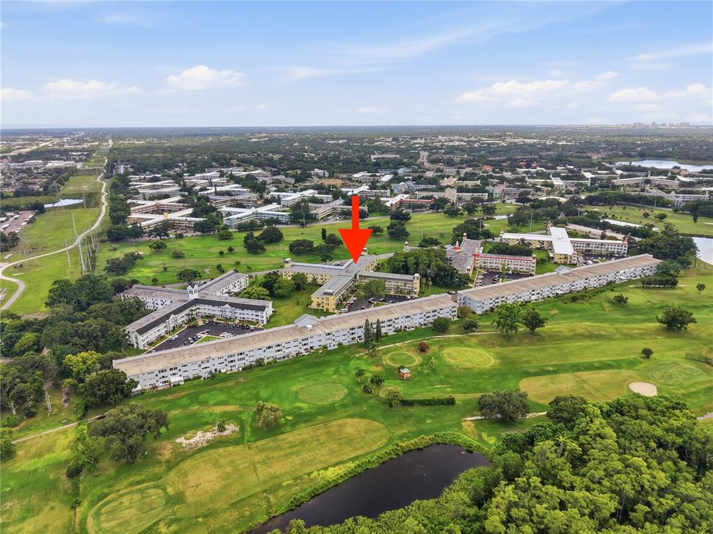 An aerial view of a multi-story apartment complex situated on a golf course — 2458 FLORENTINE WAY UNIT 34, CLEARWATER, FL